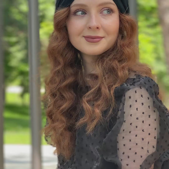 Femme souriante portant le turban Maison Dunel Ébène, assise sur un banc, style chic et décontracté